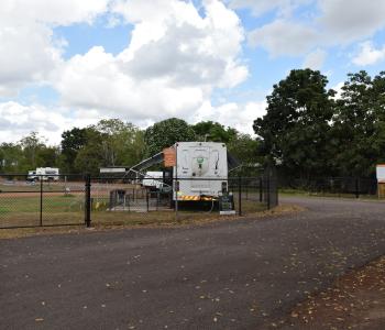 image of RV park with fence and bus parked