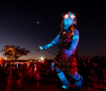 Parrtjima 2024. Arelhe Urrperle walks through the crowds
