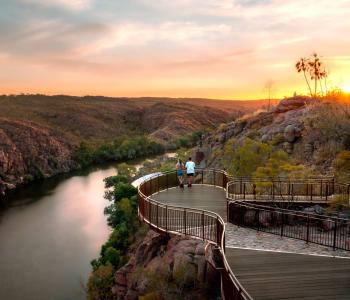 A couple stand and watch the sunset on a platform overlooking Katherine Gorge, Nitmiluk National Park
